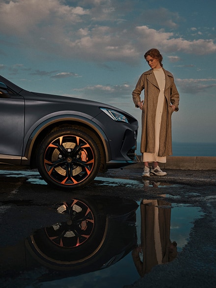 woman-standing-next-to-the new CUPRA Formentor  with brembo brakes and alloy wheels in copper
